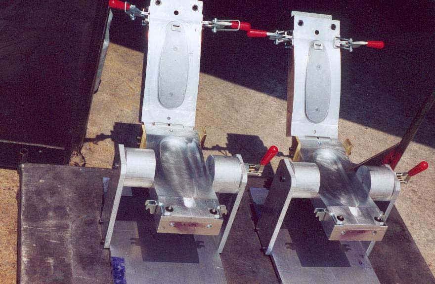 Two metal mold assemblies with red clamps